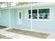 Front porch of the light teal house with white door and shutters at 12713 College Hill Dr, Hudson, FL 34667