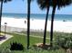 Scenic beach view with palm trees and people enjoying the sand at 17960 Gulf Blvd # 123, Redington Shores, FL 33708