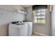 Bright laundry room, washer, dryer, and ample shelving at 32527 Osprey Peak Way, San Antonio, FL 33576