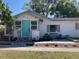 Charming single-story home with well-manicured landscaping, a blue door, and inviting curb appeal at 415 21St N St, St Petersburg, FL 33713