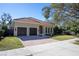 Tan house with double doors, red tile roof, and neatly trimmed lawn at 4520 W Woodmere Rd, Tampa, FL 33609