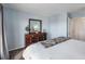 Bright bedroom featuring a wooden dresser with mirror, carpet floors, and calming light blue walls at 4939 Floramar Ter # 501, New Port Richey, FL 34652