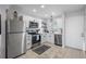 Modern white kitchen featuring stainless steel appliances, bright lighting, and tile flooring at 4939 Floramar Ter # 501, New Port Richey, FL 34652