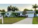 Charming single-story home featuring a well-manicured lawn and an attached garage at 6951 S Shore S Dr, South Pasadena, FL 33707