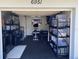 Functional garage space converted into a home gym with a rubber floor, weight equipment, and storage shelving at 6951 S Shore S Dr, South Pasadena, FL 33707