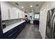 Stylish kitchen with white and dark blue cabinets, quartz countertops and patterned tile at 1005 Lake Avoca Pl, Tarpon Springs, FL 34689