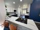 Modern kitchen with white and dark blue cabinets and a quartz island at 1005 Lake Avoca Pl, Tarpon Springs, FL 34689
