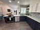Modern kitchen with white and dark blue cabinets, quartz countertops, and patterned backsplash at 1005 Lake Avoca Pl, Tarpon Springs, FL 34689