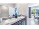 Double vanity bathroom with granite countertops and view of home office at 10609 Bridgegate Heights Loop, San Antonio, FL 33576