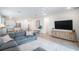Open concept living area with gray sectional, kitchen island, and hardwood floors at 11312 Gallatin Trl, Parrish, FL 34219