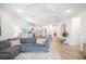 Spacious living room features gray sectional and open view to kitchen area at 11312 Gallatin Trl, Parrish, FL 34219