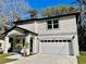 Two-story house with gray siding, a white garage door, and a landscaped yard at 16417 Lake Byrd Dr, Tampa, FL 33618