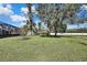 Large backyard with grassy area and mature trees at 19505 Coachlight Way, Lutz, FL 33549