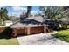 Brick house with a two-car garage and landscaped yard at 19505 Coachlight Way, Lutz, FL 33549