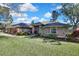 Brick house with a three-car garage and lush landscaping at 19505 Coachlight Way, Lutz, FL 33549