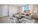 Bright living room with beige sofa and a large window offering natural light at 32746 Osprey Peak Way, San Antonio, FL 33576