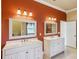 Double vanity bathroom with orange walls and white cabinets at 5269 61St N Way, Kenneth City, FL 33709