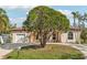 Attractive light pink house with circular driveway, lush landscaping, and a two-car garage at 5269 61St N Way, Kenneth City, FL 33709