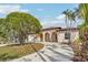 Beautiful light pink house with a large circular driveway and mature landscaping at 5269 61St N Way, Kenneth City, FL 33709