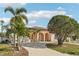 Well-maintained light pink house with palm trees, a circular driveway, and arched entryway at 5269 61St N Way, Kenneth City, FL 33709