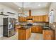 Open kitchen with island, wood cabinets, granite countertops, and stainless steel appliances at 5269 61St N Way, Kenneth City, FL 33709