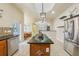 Well-equipped kitchen with island, wood cabinets, granite counters, and stainless steel appliances at 5269 61St N Way, Kenneth City, FL 33709