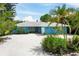 Charming mid-century home with a light blue exterior, white trim, and a gravel driveway at 616 Lyons Ln, Longboat Key, FL 34228