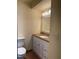 Well-maintained bathroom featuring a single sink vanity with storage and a matching toilet at 6177 Chesham Dr # 6, New Port Richey, FL 34653