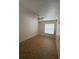 Simple bedroom with neutral walls and flooring, brightened by natural light from a window at 6177 Chesham Dr # 6, New Port Richey, FL 34653