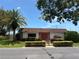 Charming Cedar Pointe building with red door, Florida palm and landscaped front bushes on a sunny day at 6177 Chesham Dr # 6, New Port Richey, FL 34653