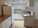 Well-lit kitchen featuring white appliances, white cabinets, and matching countertops at 6177 Chesham Dr # 6, New Port Richey, FL 34653