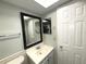 Bathroom with white vanity and black framed mirror at 215 Valencia Blvd # 105, Belleair Bluffs, FL 33770