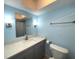 Bathroom with light blue walls and gray vanity at 215 Valencia Blvd # 105, Belleair Bluffs, FL 33770