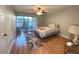 Bedroom with a bed, access to a patio, and hardwood floors at 215 Valencia Blvd # 105, Belleair Bluffs, FL 33770