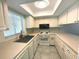 L-shaped kitchen with white cabinets and tile floor at 215 Valencia Blvd # 105, Belleair Bluffs, FL 33770