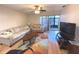 Living room with hardwood floors, sofa, and access to a screened patio at 215 Valencia Blvd # 105, Belleair Bluffs, FL 33770