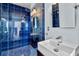 Modern bathroom features blue-tiled shower with glass door and sleek white sink at 226 5Th N Ave # 1502, St Petersburg, FL 33701