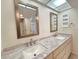 Bright bathroom featuring a double sink vanity with granite countertops and decorative mirrors at 3031 Countryside Blvd # 35C, Clearwater, FL 33761