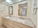Bright bathroom featuring a double sink vanity with granite countertops and decorative mirrors at 3031 Countryside Blvd # 35C, Clearwater, FL 33761