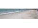 Sandy beach with gentle waves, clear water, and people enjoying the sunshine and coastal atmosphere at 3031 Countryside Blvd # 35C, Clearwater, FL 33761