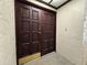 Close up of the carved double front doors with a brass kick plate and number 35 at 3031 Countryside Blvd # 35C, Clearwater, FL 33761