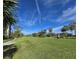 Picturesque golf course view featuring expansive green lawns, tall palm trees, and a blue sky, promoting a sense of peace at 3031 Countryside Blvd # 35C, Clearwater, FL 33761