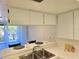 Open kitchen design with stainless steel sink and bar seating, providing a seamless transition to the living area at 3031 Countryside Blvd # 35C, Clearwater, FL 33761