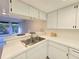 Bright kitchen featuring white cabinets, stainless sink, and a breakfast bar at 3031 Countryside Blvd # 35C, Clearwater, FL 33761