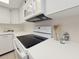 Close up view of the kitchen features white cabinetry and a black stovetop at 3031 Countryside Blvd # 35C, Clearwater, FL 33761