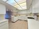 A bright kitchen with white appliances and cabinetry, laminate countertops, and a sunlit ceiling at 3031 Countryside Blvd # 35C, Clearwater, FL 33761
