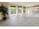 Bright living room with tile floors and access to balcony with floor to ceiling sliding doors and large potted plant at 3031 Countryside Blvd # 35C, Clearwater, FL 33761