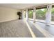 Bright living room with tile floors and access to balcony with floor to ceiling sliding doors and large potted plant at 3031 Countryside Blvd # 35C, Clearwater, FL 33761