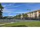 Active tennis courts with players, surrounded by lush greenery, tall palm trees, and multi-story condominium buildings at 3031 Countryside Blvd # 35C, Clearwater, FL 33761