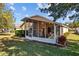 Exterior view of the house featuring a screened lanai, backyard with fresh green grass and landscaping at 4275 Caskie Pl, Brooksville, FL 34604